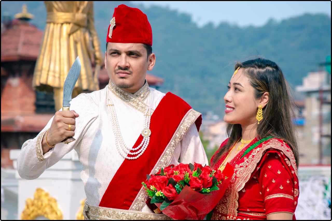 Nepali wedding couple standing together, with the groom holding a traditional ceremonial knife during the wedding ritual.